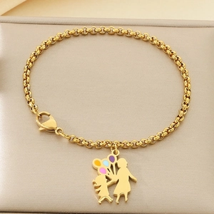 Détail du bracelet doré maman et enfant avec breloques ballons colorés sur fond cuir