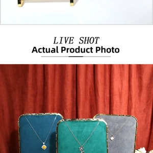 Detail view of gold necklaces with gem, butterfly and clover pendants on velvet stands