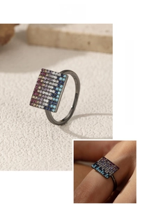 Detail view of pixel-style black S925 silver ring with turquoise and colorful diamonds
