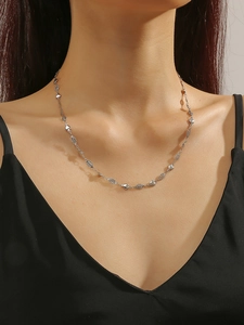 Detailed view of silver titanium steel heart necklace on model for fashion styling