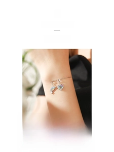 Macro view of S925 silver bracelet with rainbow wing and heart shaped keyhole charm