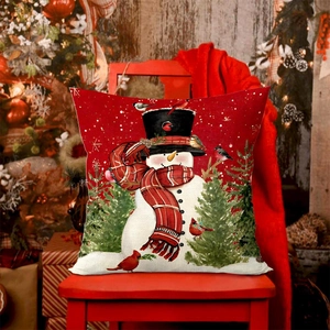 Red Christmas snowman pillow cover on wooden chair with festive tree background