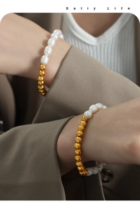 Detail of luxury freshwater pearl and gold beads bracelet styled on a model's wrist