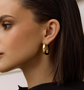 Close-up of polished gold hoop earrings for women in a minimalist fashion style