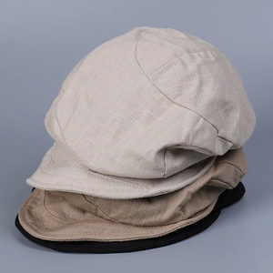 Detail of linen fabric texture on stacked beige, khaki and black stylish peaked caps