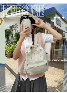 Outdoor-Streetstyle-Ansicht eines beigen Cord-Rucksacks getragen von einer Frau