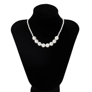 Macro detail of multi-layer pearl necklace with heart pendant on a black bust