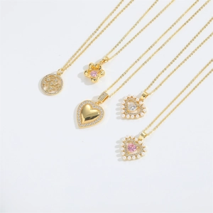 Close-up of five assorted gold-tone heart and flower necklaces on a white background