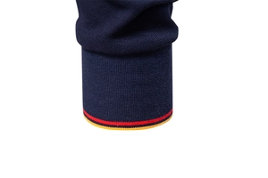 Detail of ribbed navy polo shirt cuff featuring distinctive red and yellow stripes