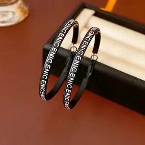 Chic black leather hoop earrings featuring repeat white lettering on a stylish box edge