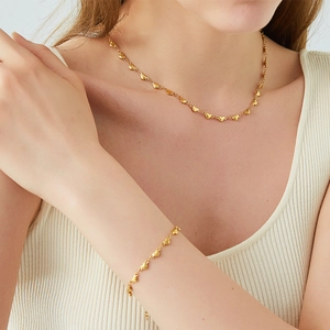 Elegant 18K gold plated heart link necklace and bracelet set worn by a model