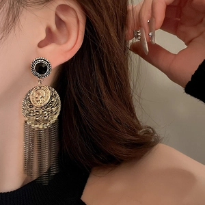 Bohemian gold coin portrait earrings with long layered metal tassels on a fashion model