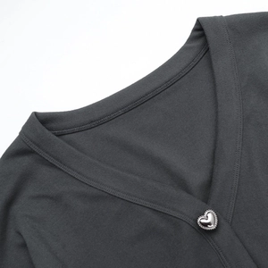 Détail d'une robe en maille gris foncé avec col en V et boutons argentés en cœur
