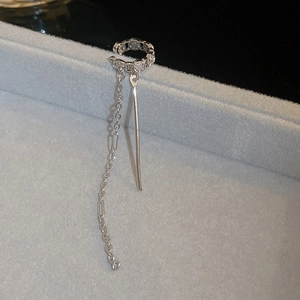 Detailed view of a silver zircon butterfly tassel ear cuff on a velvet display stand