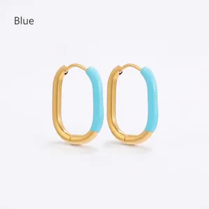 Close-up of U-shaped oval earrings with gold plating and light blue enamel inlay