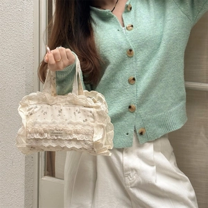 Détail du sac cabas en toile florale avec bordures en dentelle et étiquette tissée