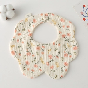 Macro shot of petal-shaped cotton gauze baby bib with delicate pink floral pattern