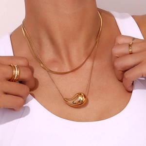 Detail of 18K gold-plated double-layer necklace with bean pendant and matching rings
