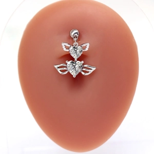 Macro detail of silver heart belly ring with angel wings and white cubic zirconia stones