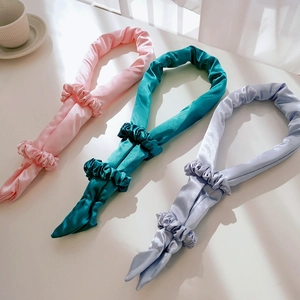 Detailed set of satin heatless hair curlers in pink, teal, and light blue with scrunchies