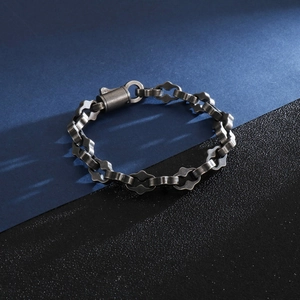 Gros plan d'un bracelet gourmette punk industriel en argent antique avec texture métallique