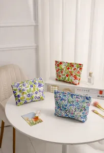 Colección de bolsas de maquillaje florales en una mesa con accesorios de estilo de vida