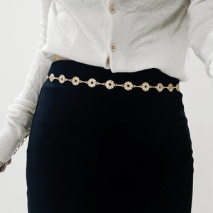 Detail of gold metal chain belt featuring rhinestone-encrusted circular links for women