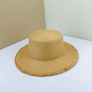 Close-up of natural straw weave texture and frayed edges on a flat top beach sun hat