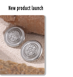 Macro shot of silver metal stud earrings with celtic pattern and textured beaded edges