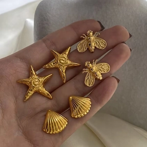 Golden stainless steel earring set featuring starfish, bee, and seashell designs on hand