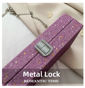 Detail of silver hardware clasp on purple glitter clutch with sparkling star sequins