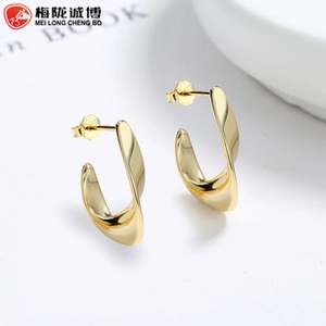 Detailed view of twisted gold hoop earrings with a high-polished metallic finish