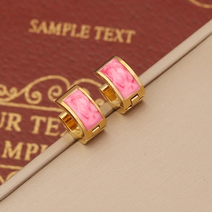 Elegant gold-plated huggie earrings with pink marble enamel inlay on beige pedestal