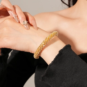 Vue détaillée du bracelet doré scintillant à plusieurs rangées de strass sur le poignet
