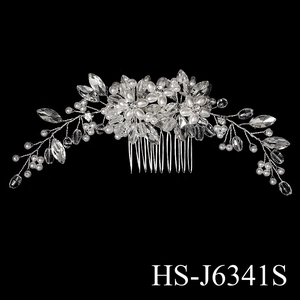 Detail of bridal hair comb with silver crystal flowers and pearls on black background