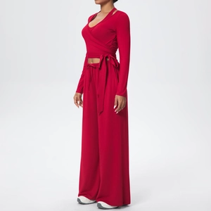 Détail de l'ensemble de yoga rouge avec haut cache-cœur à manches longues et pantalon