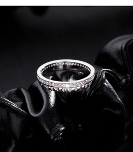 Macro shot of S925 sterling silver eternity band with micro-pave crystals on black leather