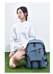Blue-grey large capacity backpack for students shown in a casual outdoor lifestyle setting