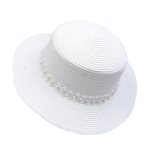 Detail of white straw hat with elegant pearl and lace ribbon trim on a flat top design