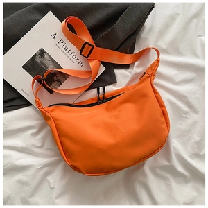 Detailed top view of an orange nylon crescent crossbody bag with adjustable wide strap