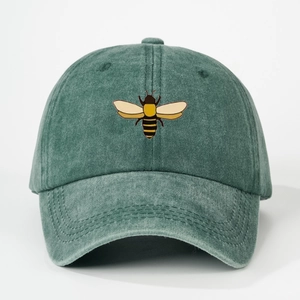 Detailed embroidery of a colorful bee on washed green cotton canvas baseball cap
