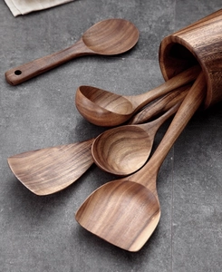 Macro shot of acacia wood kitchen utensils set with a matching storage holder