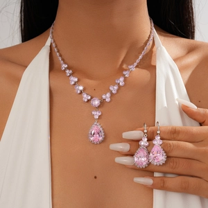 Detail of pink zircon flower and teardrop jewelry set on model with silver finish