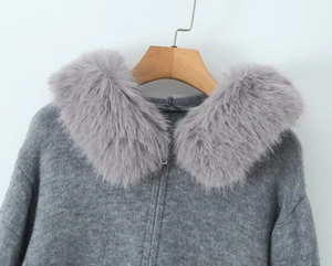 Detailed view of grey knitted cardigan with fluffy faux fur collar and metal zipper