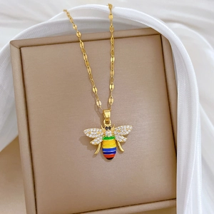 Macro view of a gold bee pendant with rhinestones and enamel on a jewelry box