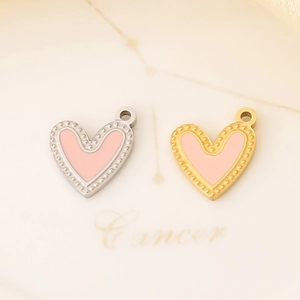 Detail of pink enamel heart pendants in gold and silver stainless steel frames