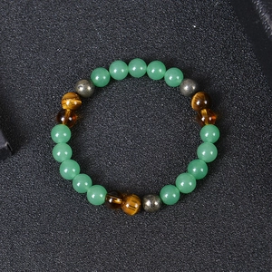 Macro detail of natural tiger eye and turquoise beads on an elastic wealth bracelet
