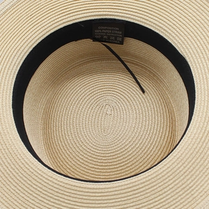 Détail de l'intérieur d'un chapeau de paille avec bandeau noir et étiquette 100% papier