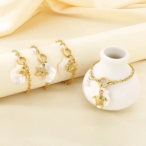 Detailed shot of golden sea charms bracelet with pearls, shells, and starfish accents