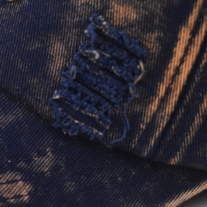 Macro detail of vintage washed blue denim baseball cap with distressed rips and leopard print